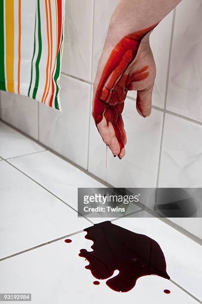 a human hand hanging from a bathtub with blood puddled beneath it - sangue umano foto e immagini stock