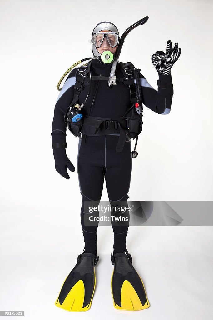 A scuba diver giving the OK sign, studio shot