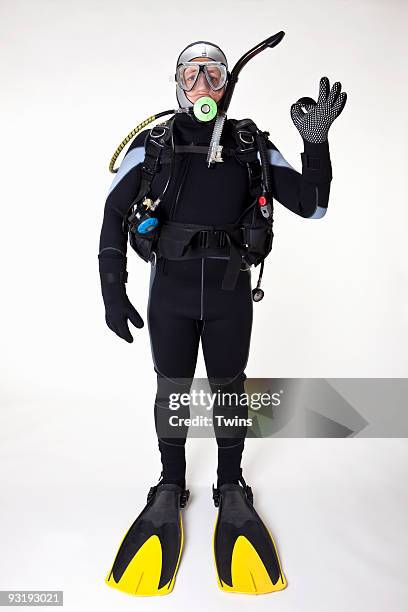 a scuba diver giving the ok sign, studio shot - equipamento de mergulho equipamento de desporto aquático imagens e fotografias de stock