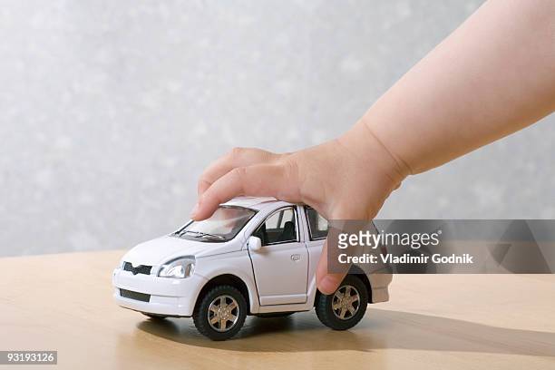 a child playing with a toy car - toy car foto e immagini stock