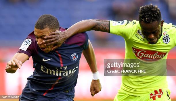 Paris Saint-Germain's French forward Kylian MBappe vies with Angers' Ivorian defender Abdoulaye Bamba during the French Ligue 1 football match...