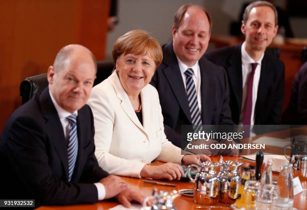 German Finance Minister and Vice-Chancellor Olaf Scholz, German Chancellor Angela Merkel and German Chief of Staff Helge Braun smile at the start of...