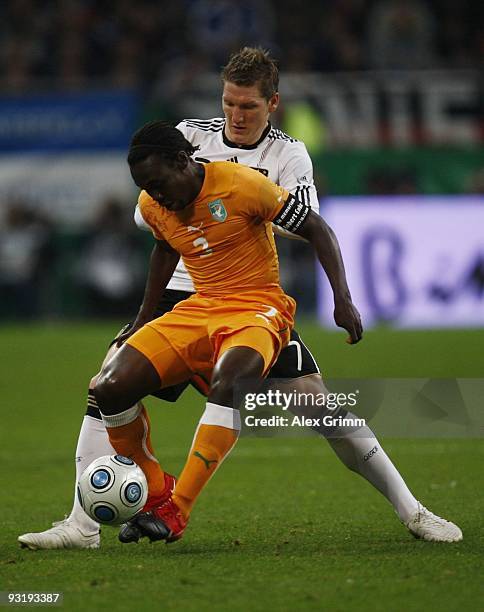 Bastian Schweinsteiger of Germany and Arthur Boka of Ivory Coast battle for the ball during the international friendly match between Germany and...