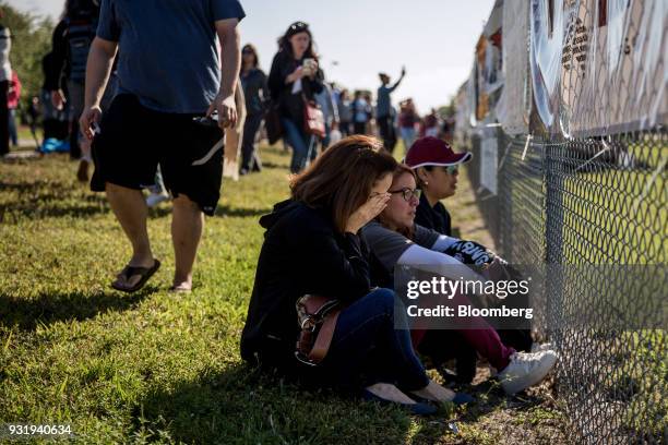 People sit outside as students participate during the ENOUGH: National School Walkout rally at Marjory Stoneman Douglas High School in Parkland,...