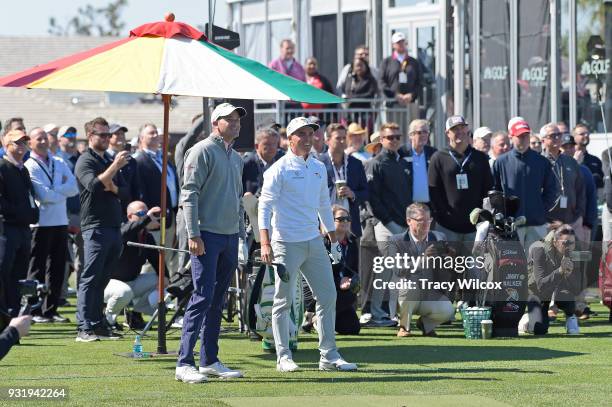 Sam Saunders and Rickie Fowler watch as players hit shots on the range at the Opening Ceremony during practice for the Arnold Palmer Invitational...