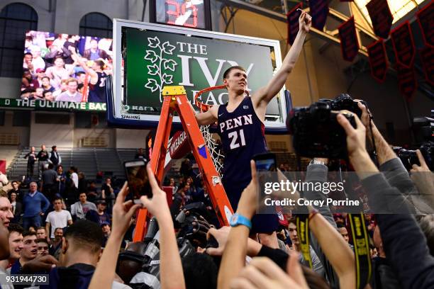 Ryan Betley of the Pennsylvania Quakers holds up a piece of netting after the win at The Palestra on March 11, 2018 in Philadelphia, Pennsylvania....