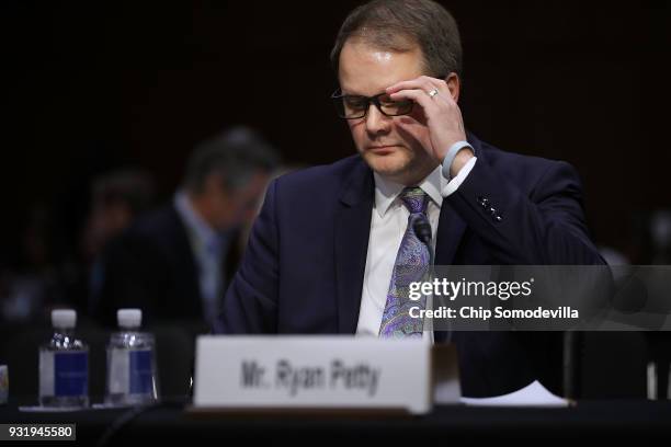 Ryan Petty, father of Alaina Petty, a student killed in the February 14 shooting in Parkland, Florida, wipes away tears while testifying before the...