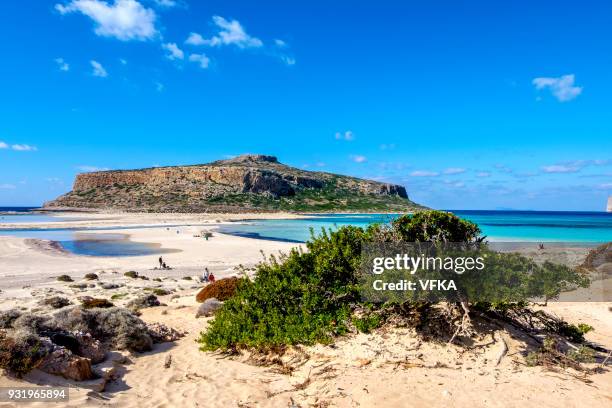 people on the beach at vibrant blue balos beach lagoon, gramvousa, crete, greece - balos lagoon stock pictures, royalty-free photos & images