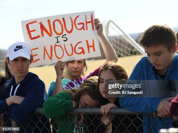 Leah Zundel a students at Columbine High School, holds a sign that reads "Enough is Enough" as she and other students walked out of classes in...