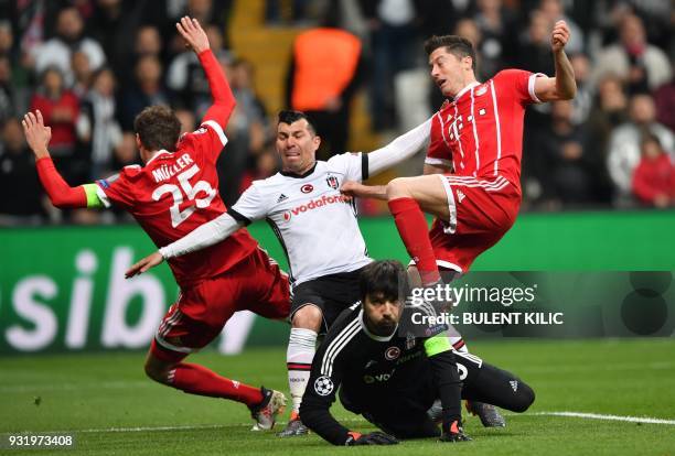 Besiktas midfielder Gary Medel and Besiktas goalkeeper Tolga Zengin fight for the ball with (Bayern Munich's German forward Thomas Mueller and Bayern...