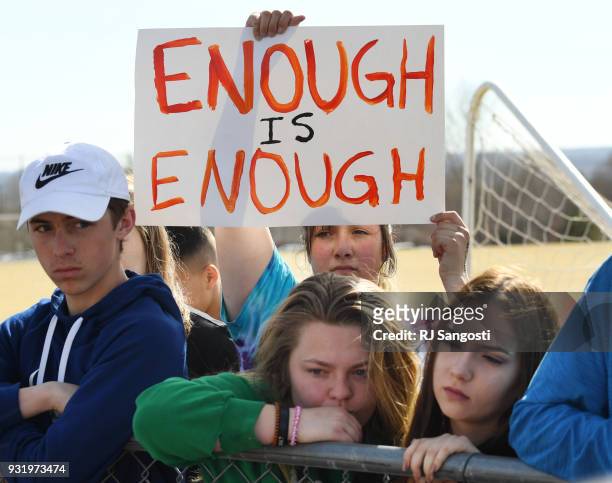Leah Zundel a students at Columbine High School, holds a sign that reads "Enough is Enough" as she and other students walked out of classes in...