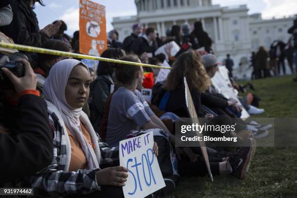 Students sit outside the U.S. Capitol building during the ENOUGH: National School Walkout rally in Washington, D.C., U.S., on Wednesday, March 14,...