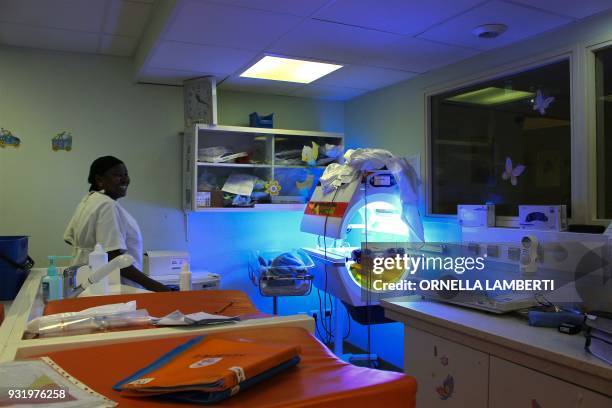 Nurse stands by a phototherapy unit machine in the nursery and intensive care unit of the maternity ward at the Mayotte Maternity Hospital in...