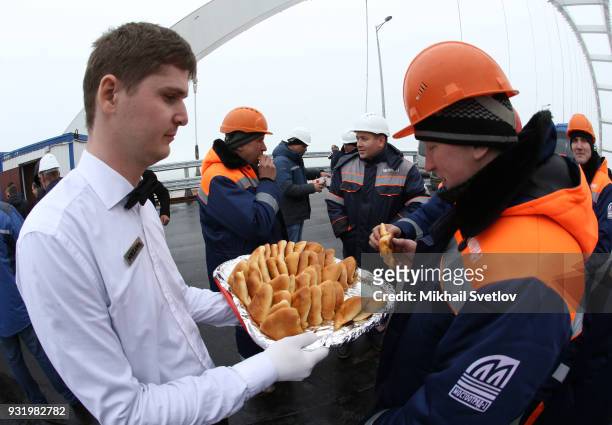Worker takes a cake at the construction site for the Crimean bridge which is being built to connect the Krasnodar region of Russia and Crimean...