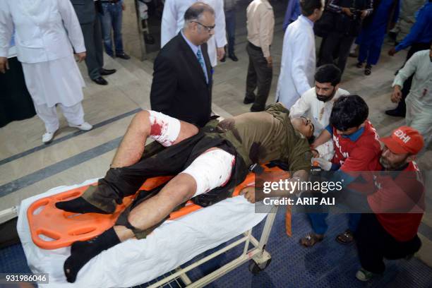 Pakistani volonteers push a stretcher carrying an injured blast victim to the hospital following a motorcycle bomb attack in Lahore on March 14,...