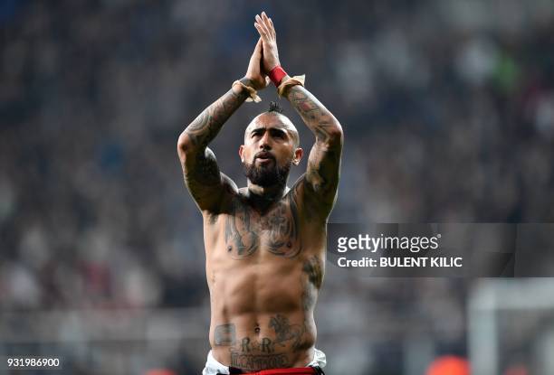 Bayern Munich's Chilean midfielder Arturo Vidal applauds supporters after the second leg of the last 16 UEFA Champions League football match between...