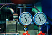 Close-up of two pressure gauges with red valves