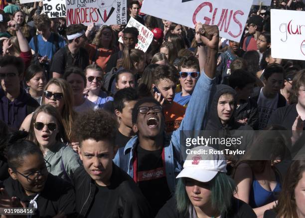Aaron Durst a student at East High School in Denver, raises his hand in protest against gun violence on the Colorado State Capitol grounds on March...