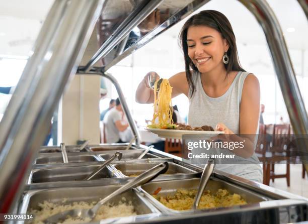 vrouw met gerechten op een buffet restaurant - buffet stockfoto's en -beelden