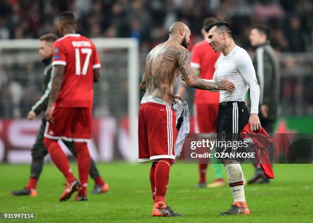 Besiktas midfielder Gary Medel exchanges shirts with Bayern Munich's Chilean midfielder Arturo Vidal after the second leg of the last 16 UEFA...