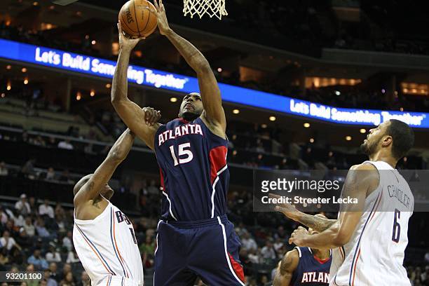 Al Horford of the Atlanta Hawks goes to the basket over Raja Bell and Tyson Chandler of the Charlotte Bobcats during the game on November 6, 2009 at...