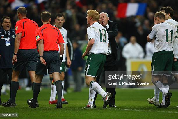 Liam Brady the assistant coach of Ireland restrains players including Paul McShane as they dispute with referee Martin Hansson after the FIFA 2010...