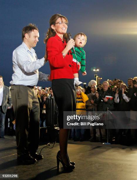 Former Republican vice presidential candidate and Alaska Governor Sarah Palin holds one of her children as arrives for a book signing event for her...