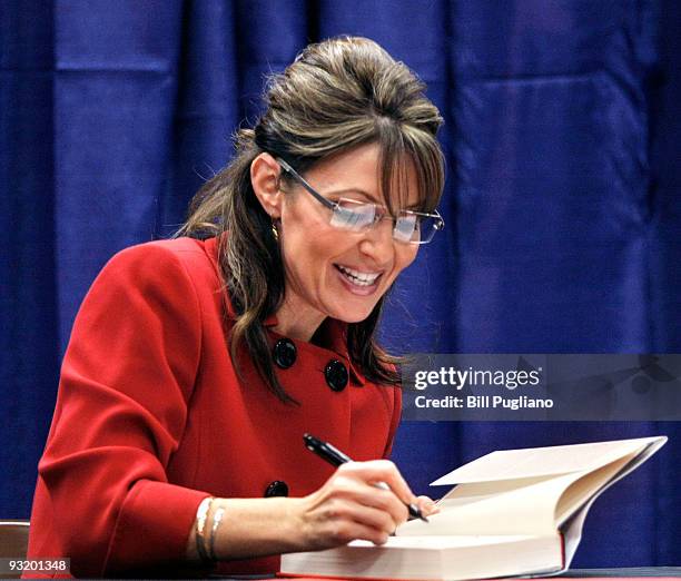 Former Republican vice presidential candidate and Alaska Governor Sarah Palin signs her new book, "Going Rogue" for a customer at a Barnes & Noble...
