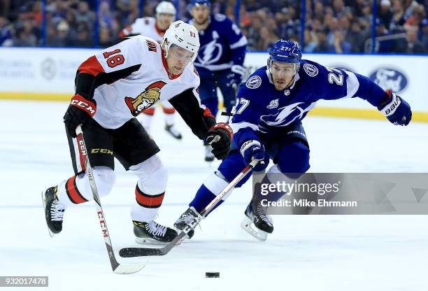 Ryan McDonagh of the Tampa Bay Lightning and Ryan Dzingel of the Ottawa Senators fight for the puck during a game at Amalie Arena on March 13, 2018...