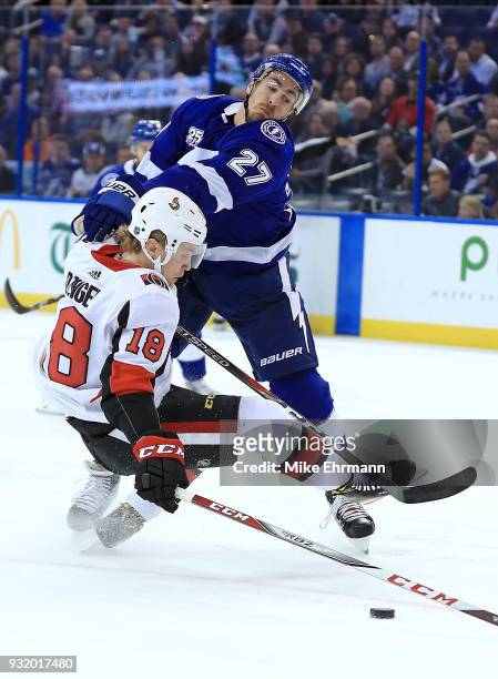 Ryan McDonagh of the Tampa Bay Lightning and Ryan Dzingel of the Ottawa Senators fight for the puck during a game at Amalie Arena on March 13, 2018...