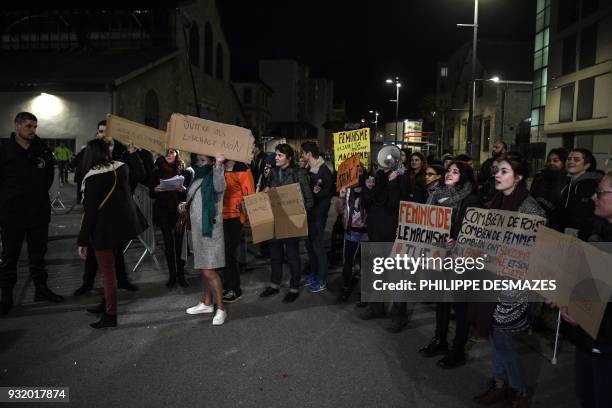 Protestors hold banners reading messages like "Feminicide the male chauvinism kills" on March 14, 2018 in front of "La belle electrique" venue,...