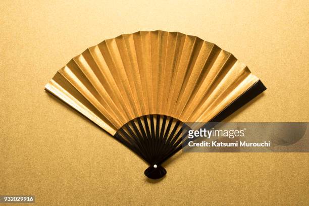 golden folding fan background - folding fan stock pictures, royalty-free photos & images