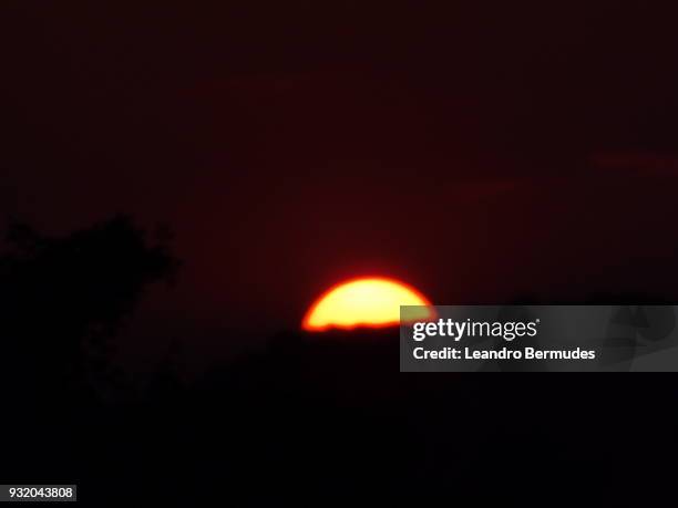 sun setting behind a mountain. - leandro bermudes stock pictures, royalty-free photos & images