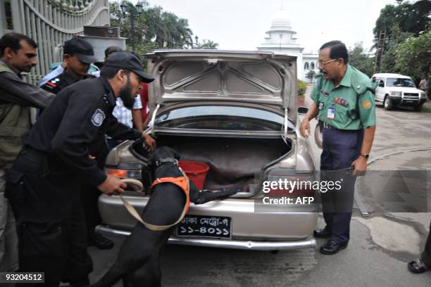 To go with Bangladesh-politics-security-Mujib-justice by Shafiq Alam A sniffer dog from the Bangladeshi Rapid Action Battalion squad searches a car...