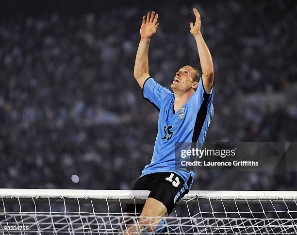 Diego Perez of Uruguay celebrates by climbing onto the crossbar after the 2010 FIFA World Cup Play Off Second Leg Match between Uruguay and Costa...