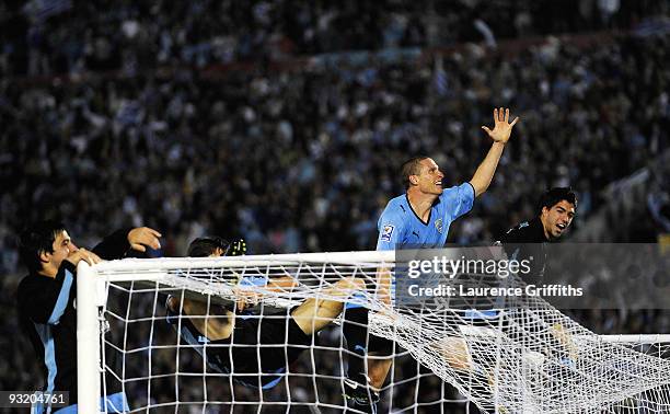 Diego Perez of Uruguay celebrates by climbing onto the crossbar after the 2010 FIFA World Cup Play Off Second Leg Match between Uruguay and Costa...