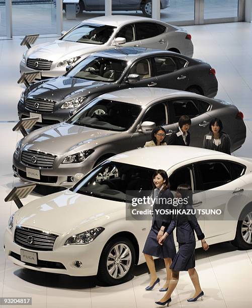 Employees for Japanese auto giant Nissan Motor prepare for a presentation of the company's new luxury sedan "Fuga", equipped with 2.5 or 3.7-litre V6...