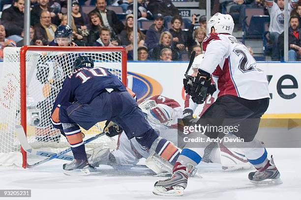 Shawn Horcoff of the Edmonton Oilers lunges to poke the puck past Peter Budaj of the Colorado Avalanche for a first period goal at Rexall Place on...