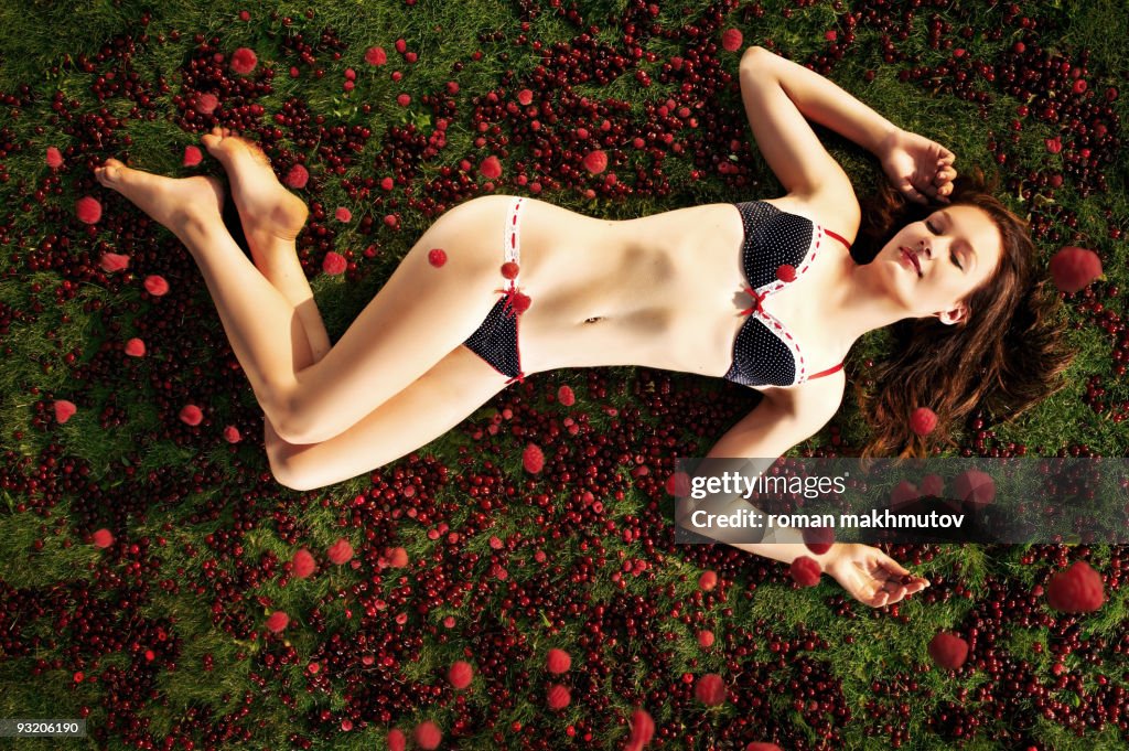 Young woman lying in the cherries