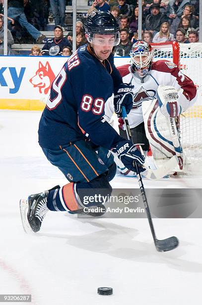 Sam Gagner of the Edmonton Oilers carries the puck under the watchful eye of goaltender Peter Budaj of the Colorado Avalanche at Rexall Place on...