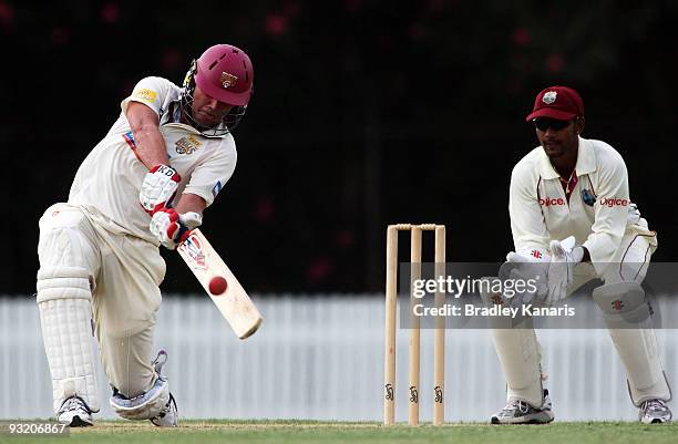 Nick Kruger of the Bulls hits the ball over the boundary for a six during day two of the tour match between the Queensland Bulls and the West Indies...