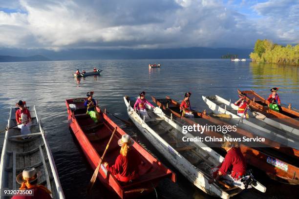 Women of Mosuo ethnic group row boats at Lugu Lake area on October 15, 2017 in Liangshan Yi Autonomous Prefecture, Sichuan Province of China. Lugu...