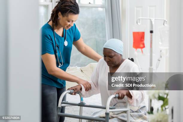 home healthcare provider helps a senior woman - hospice stock pictures, royalty-free photos & images