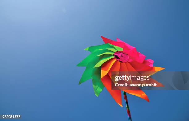 colourful pinwheel against clear blue sky - paper windmill stock pictures, royalty-free photos & images
