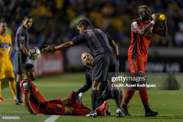 Referee Hector Rodriguez asks Justin Morrow of Toronto to leave the field to receive medical aid during the quarterfinals second leg match between...