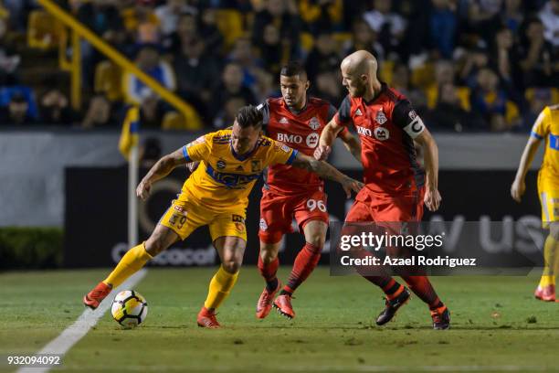 Eduardo Vargas of Tigres fights for the ball with Auro Junior and Michael Bradley of Toronto during the quarterfinals second leg match between Tigres...