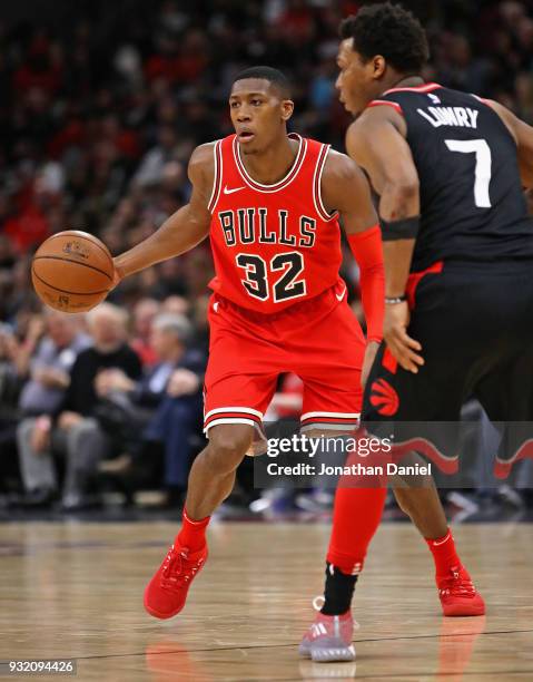 Kris Dunn of the Chicago Bulls looks to pass against Kyle Lowry of the Toronto Raptors at the United Center on February 14, 2018 in Chicago,...