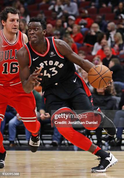 Pascal Siakam of the Toronto Raptors drives past Paul Zipser of the Chicago Bulls at the United Center on February 14, 2018 in Chicago, Illinois. The...