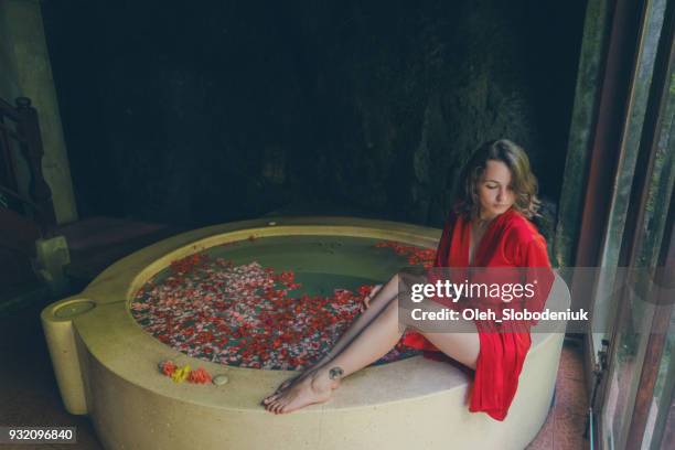 woman taking hot tub with flower petals - robe rose stock pictures, royalty-free photos & images