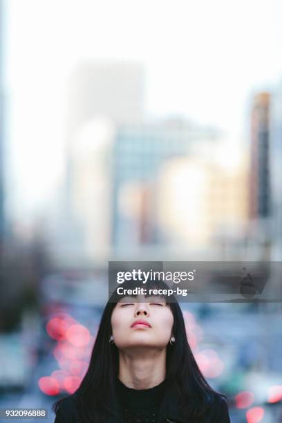 若い女性の whileher 市では、閉じた目の肖像 - sad face ストックフォトと画像